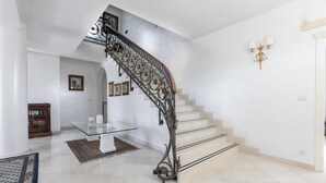 Un interior moderno con una escalera curva, una mesa de vidrio y un diseño minimalista.