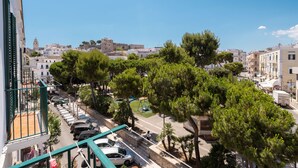 Vista de una calle con coches estacionados, árboles y edificios.