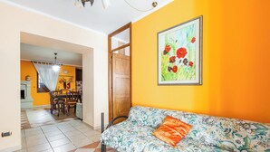 Quarto com sofá, quadro e espaço de refeições.
