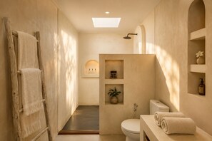 Un baño moderno con ducha, inodoro y tocador.