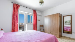 A bedroom with a bed, a wardrobe, a window with curtains, and a ceiling fan. - Casa Sapore by BarbarHouse (San Pietro in Bevagna)