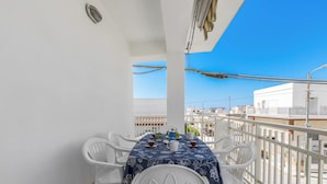 A balcony with a table set for two, white chairs, and a blue tablecloth. - Casa Sapore by BarbarHouse (San Pietro in Bevagna)