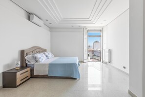 A bedroom with a bed, nightstand, and a view of the outside. - La Casa sulla Piazza by BarbarHouse (Monopoli)