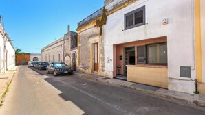 Une rue bordée de voitures garées et d’immeubles.