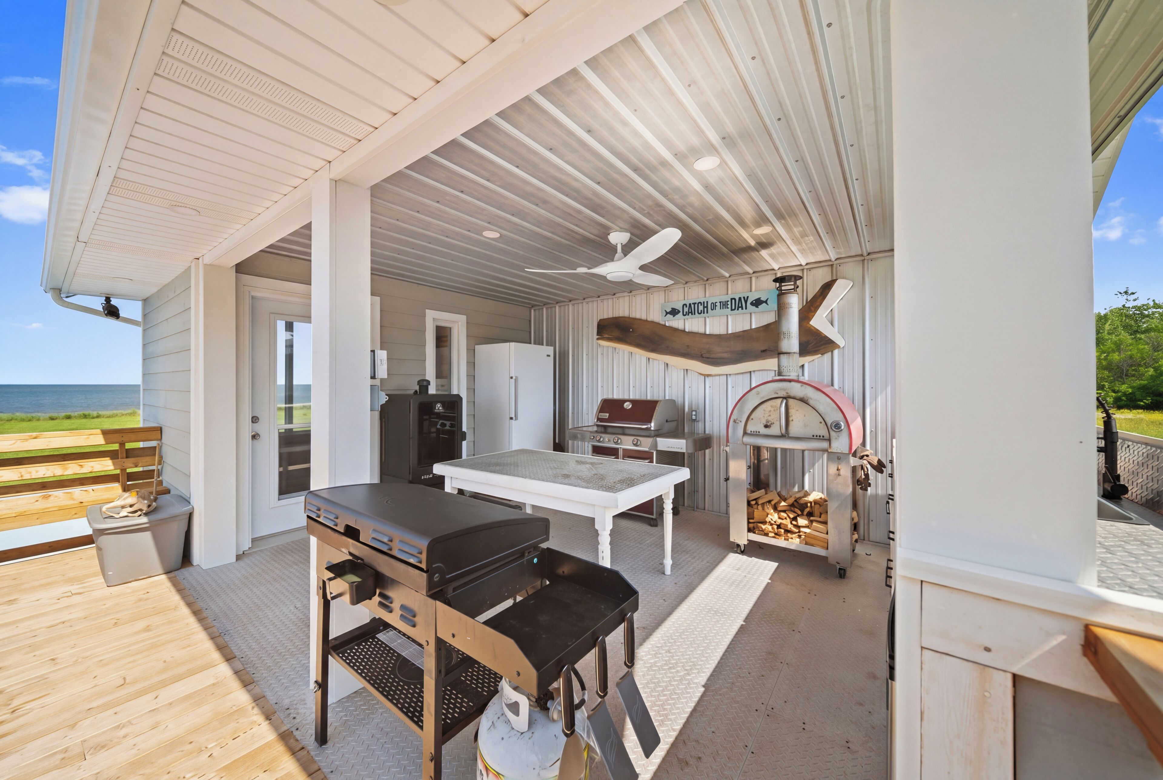 Un espace extérieur abrité comprenant un barbecue, une table et un coin pour faire des grillades.