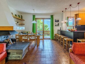 Ein gemütliches Wohnzimmer mit Kamin, Essbereich und Küche.