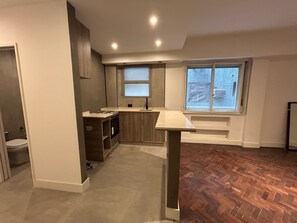 A modern kitchen with a built-in oven, a sink, and a window overlooking a cityscape. - Beautiful 1 bedroom apartment in the center of Buenos Aires city (City of Buenos Aires)