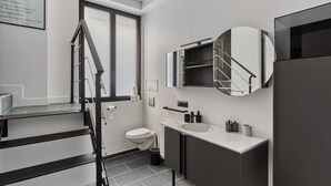 Ein modernes Badezimmer mit Toilette, Waschbecken und einem Spiegel mit integriertem Ablagefach.