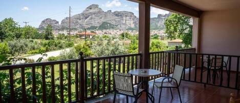 Un balcon avec vue sur la montagne et la ville.