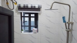 A bathroom with a toilet, a shower, and a small window. - Welcoming 1-bedroom apartment with AC in vibrant (Ikeja)