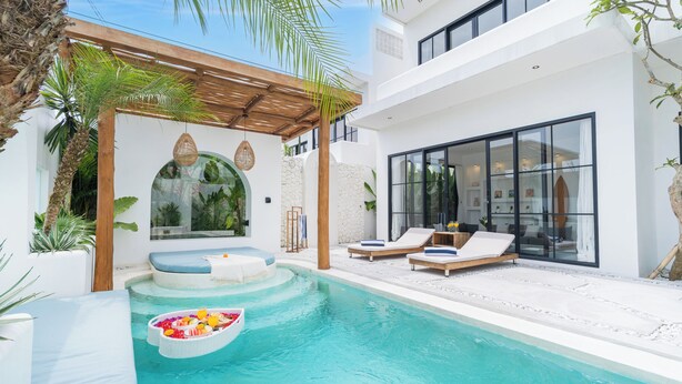 Un área de piscina moderna con sillones de descanso, un jacuzzi y una pérgola.