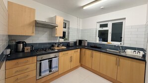 Una cocina moderna con armarios de madera, cocina a gas, microondas y ventana con vistas.