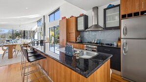 Een moderne keuken met een centraal eiland, roestvrijstalen apparatuur en houten keukenkastjes.