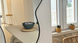 Ein modernes Interieur mit einem großen Spiegel, einem Essbereich und Blick auf den Außenbalkon.