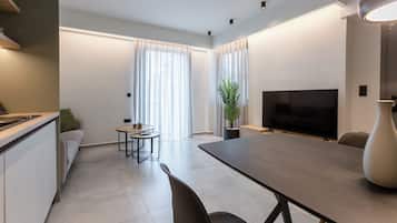 Un salon moderne avec une table à manger, un canapé, un téléviseur et une plante en pot.