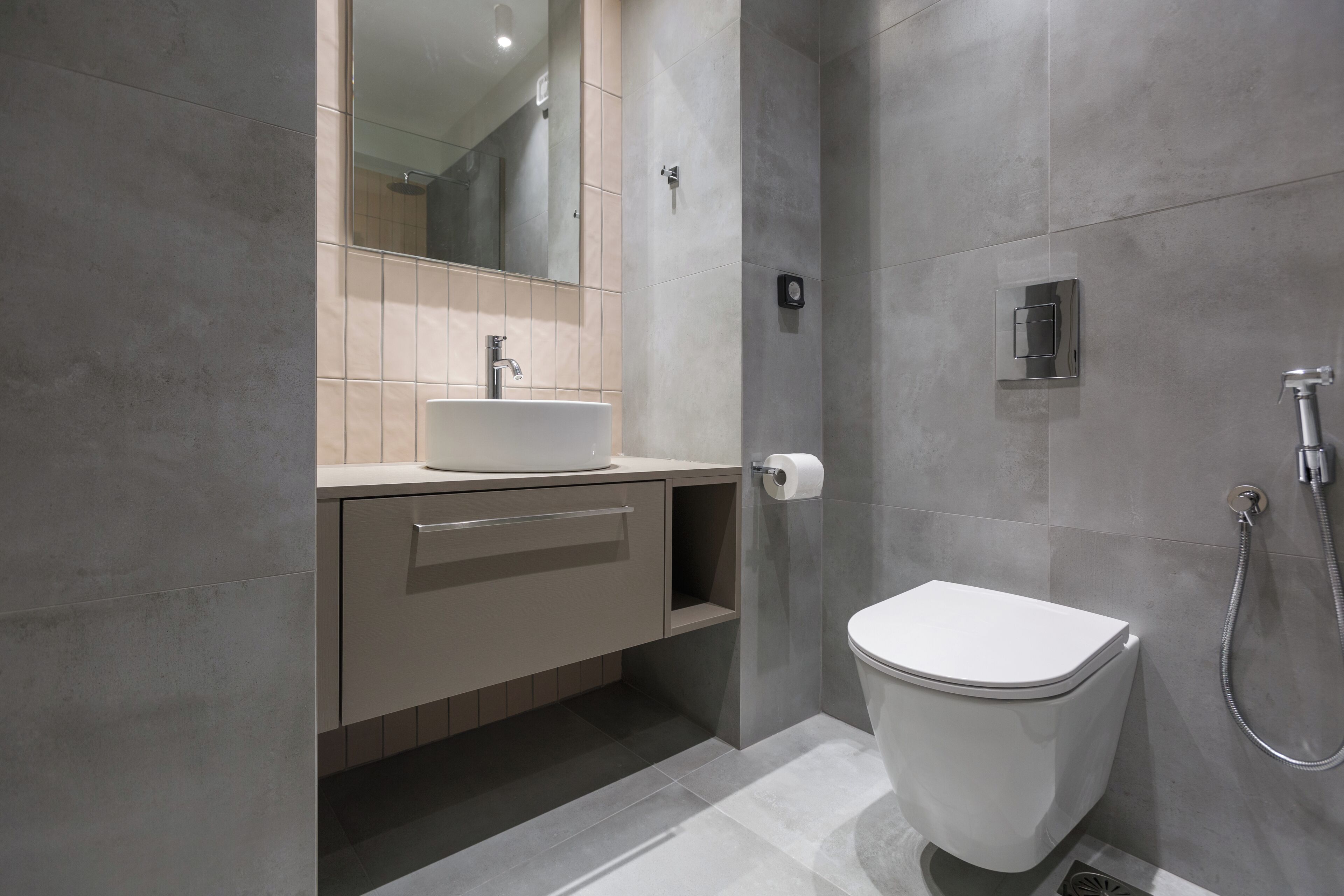 A modern bathroom with a toilet, sink, and shower.