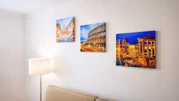Ein Zimmer mit einer Couch, einer Lampe und drei Bildern berühmter Wahrzeichen.