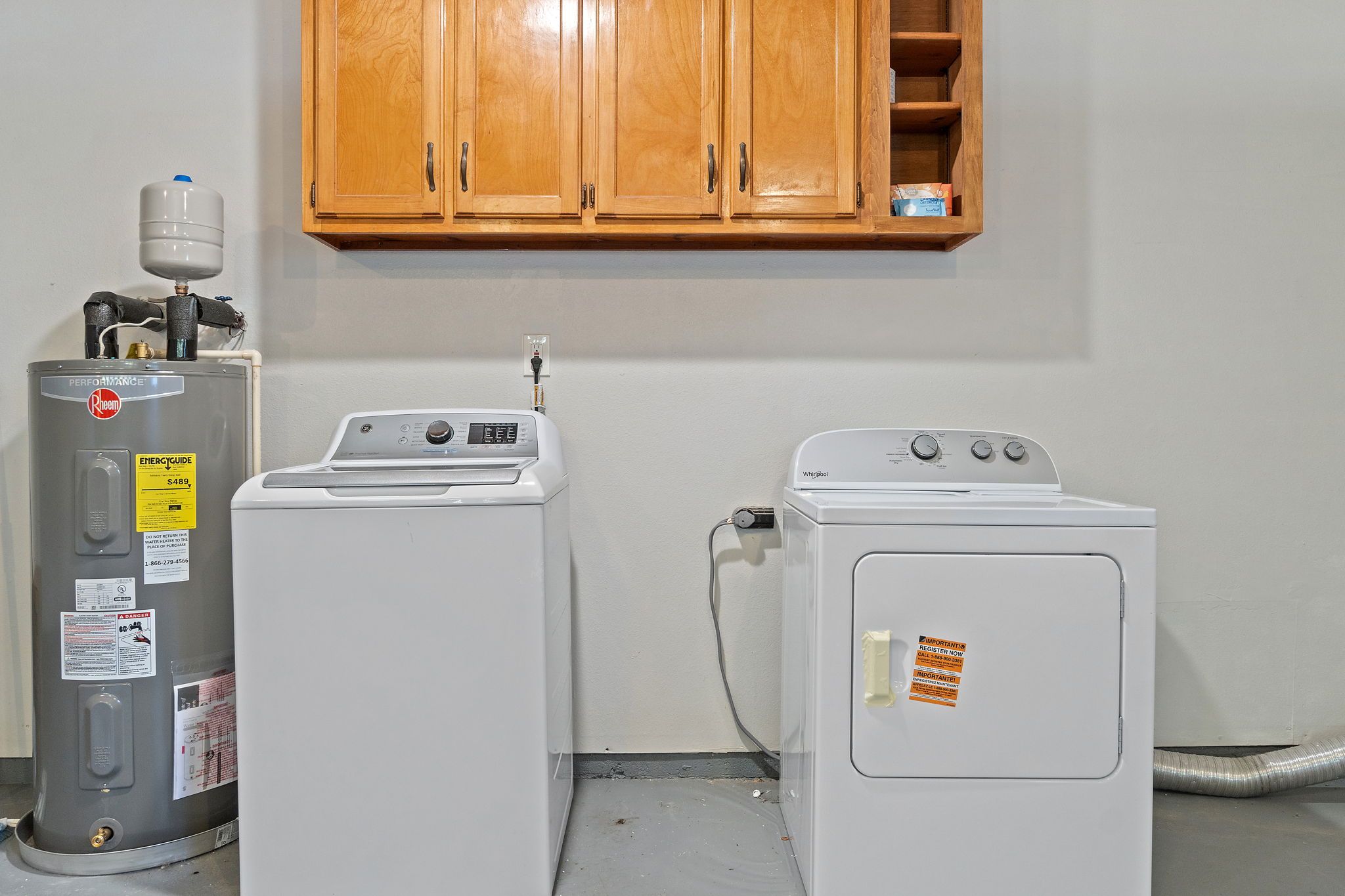 A laundry room with a water heater, a washing machine, and a dryer.