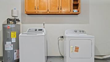 A laundry room with a water heater, a washing machine, and a dryer.