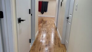 A hallway with wooden flooring and white walls.