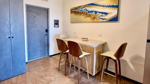 Un coin repas avec une table et des chaises, un ventilateur de plafond et un tableau accroché au mur.