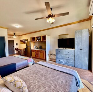 A hotel room with a bed, a desk with a chair, a kitchenette, a TV, and a wardrobe. - Condo Loft next to Cerritos Beach, Pescadero BCS (Cerritos pescadero)