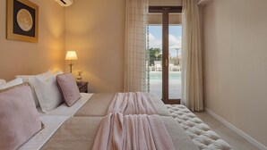 A hotel room with a bed, a nightstand with a lamp, a wall-mounted air conditioner, and a view of a pool through a glass door. - Anesis - Three Bedroom Villa, Sleeps 6 (Fiskardo)