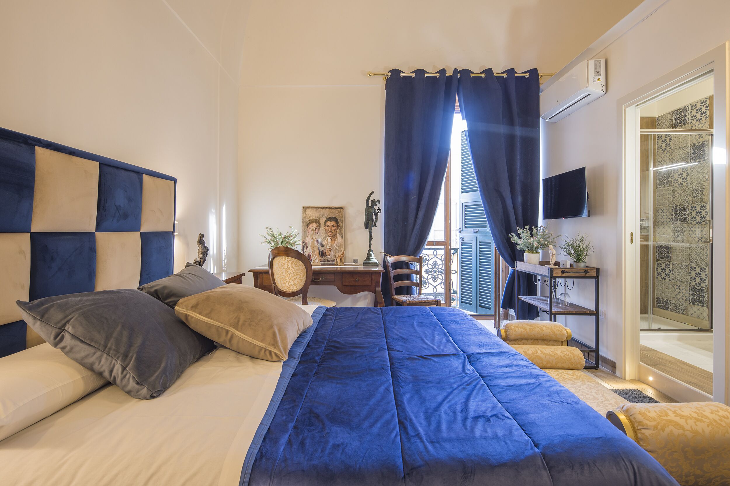 Un dormitorio con cama, escritorio, silla y televisor.