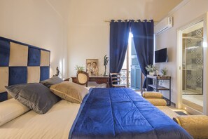 A bedroom with a bed, a desk, a chair, and a television. - pompei suite via roma 16 (Pompei)