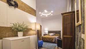 Una camera da letto compatta con un letto, un comodino e una pianta in vaso.