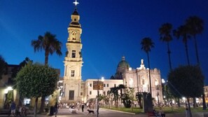 A historic building with a prominent clock tower and a dome, surrounded by palm trees and a plaza with people. - pompei suite via roma 16 (Pompei)