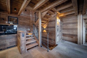 Un intérieur en bois comprenant un escalier, un coin cuisine et un four encastré.