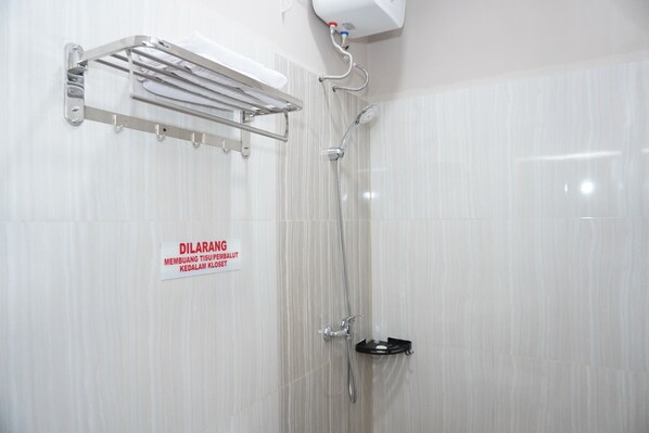 A shower with a handrail, a wall-mounted towel rack, and a sign indicating a no-smoking policy.