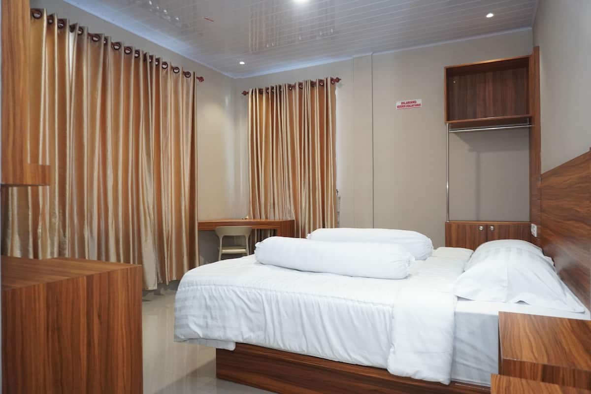 Une chambre d’hôtel avec un lit en bois, un bureau, une armoire et des rideaux.