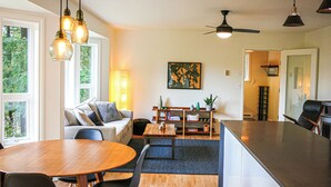 Una cocina moderna con una isla central, un comedor con mesa redonda y un espacio de estar con sofá.