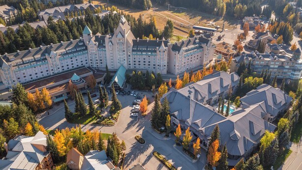 Un grand hôtel composé de plusieurs bâtiments, avec une cour centrale et des arbres qui l’entourent.