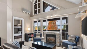 Un salon moderne avec une cheminée, un canapé, une table basse et une bibliothèque.