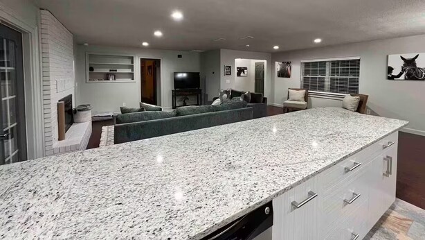 A modern kitchen with granite countertops, a built-in oven, and a dishwasher.