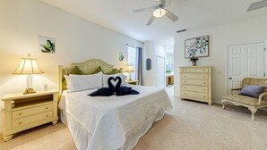 A bedroom with a bed, nightstands, a dresser, a chair, and a ceiling fan. - Spacious 5 bedroom Florida villa (Davenport)