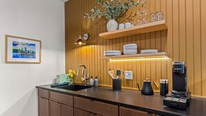 Eine moderne Küche mit Holzvertäfelung, einer Kaffeemaschine und einem Spülbecken.