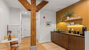 Eine moderne Küche mit Holzausstattung, einer Marmorarbeitsplatte und sichtbaren Holzbalken.