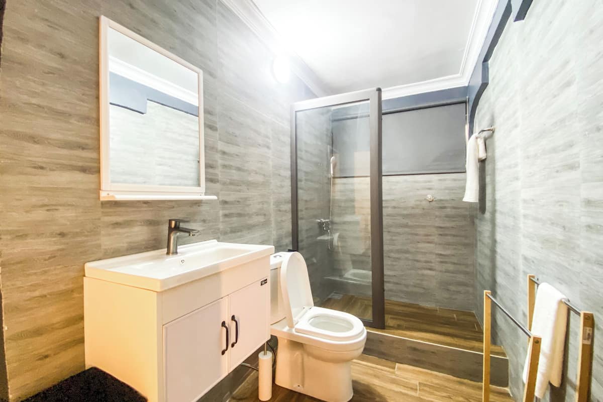 Ein modernes Badezimmer mit einem weißen Waschtisch, einer Toilette und einer Duschkabine.