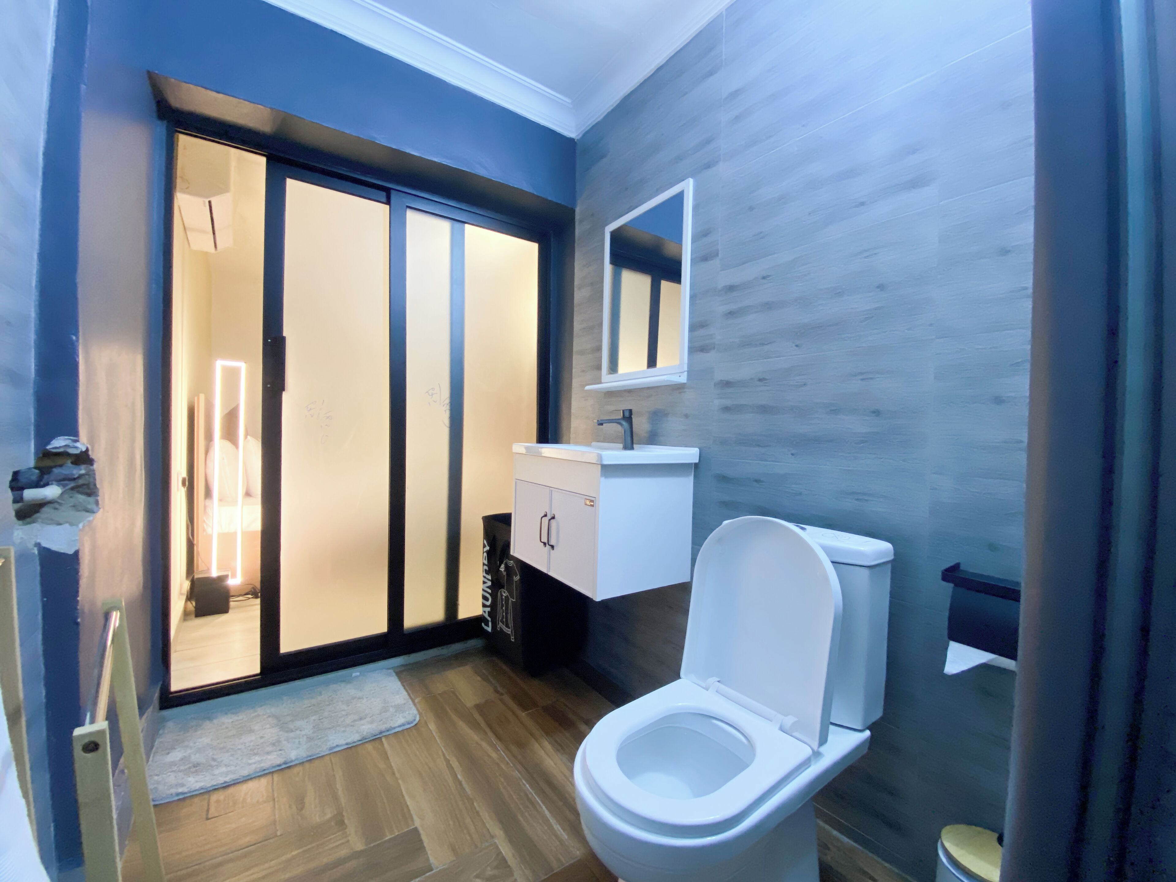 A modern bathroom with a toilet, sink, and mirror.