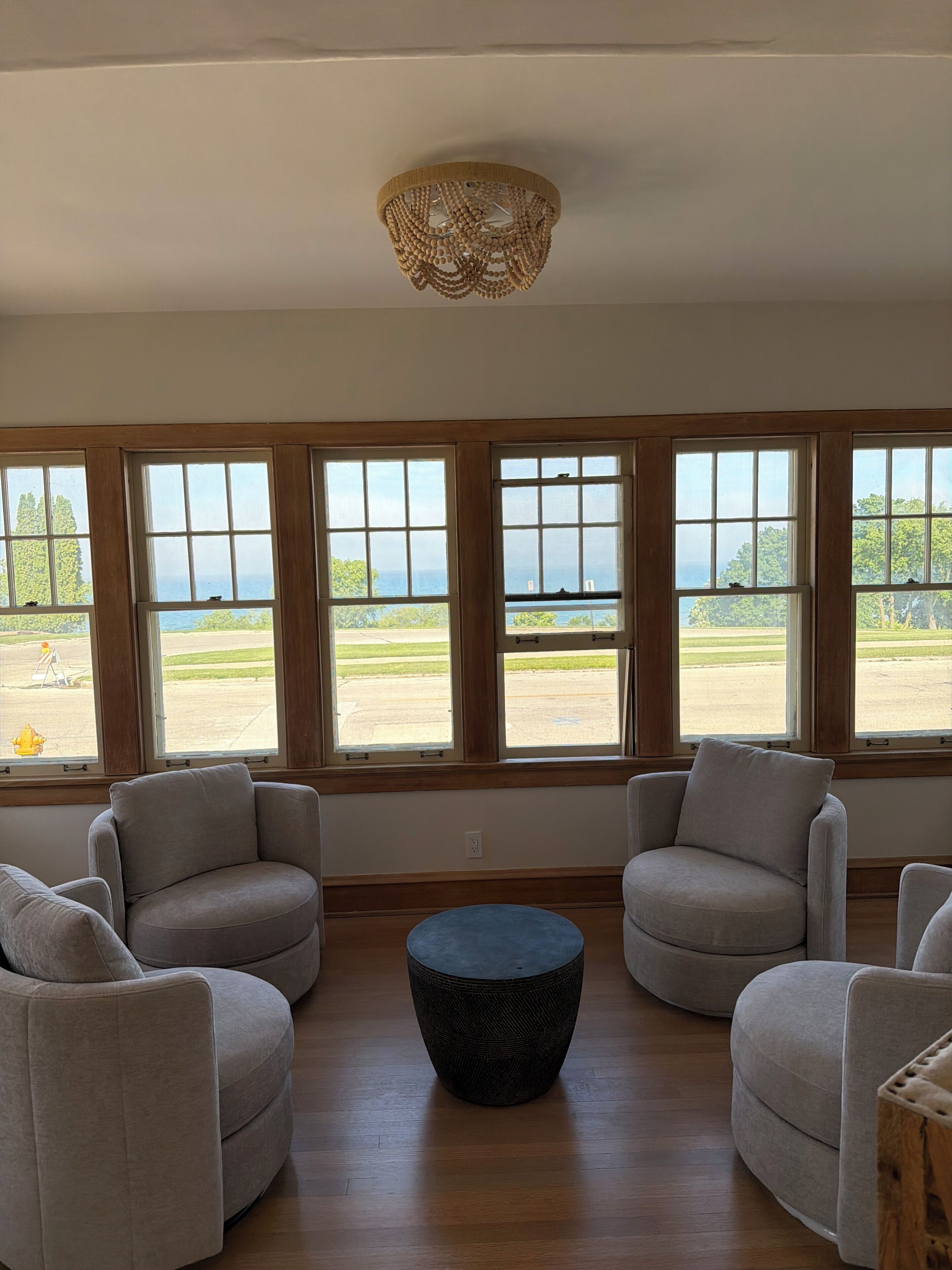 Habitación con vistas a un campo de golf, ventanas amplias y una mesa redonda central.