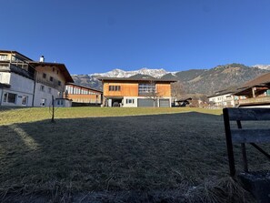A modern building with a garage, surrounded by a grassy area and mountains in the background. - Valley Appartement by Interhome (Frutigen)