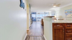Una cucina con mobili in legno, un piano di lavoro e vista all'esterno.