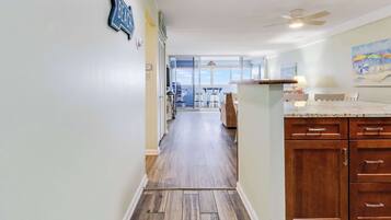 A kitchen with wooden cabinets, a countertop, and a view to the outside.