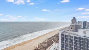 Paesaggio costiero con spiaggia, edifici e cielo sereno.