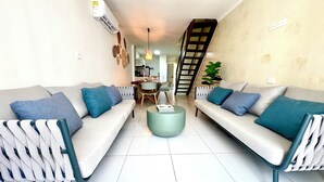 A living room with two sofas, a coffee table, and a staircase leading to another level. - Cozy duplex apartment at the City Center (Cartagena de Indias)