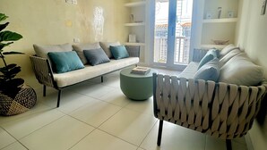 A living room with a sofa, armchair, and a round coffee table. - Cozy duplex apartment at the City Center (Cartagena de Indias)